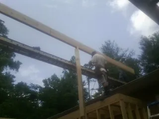 Carpenter setting a ridge beam over a new addition frame — Ice Dam Removal by Roofing Brothers in Easton