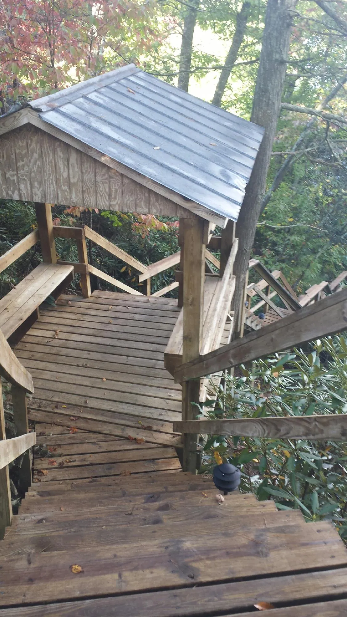 Metal roofed shelter over wooden steps on a wooded walkway — Skylight Repair & Installation work by our crew in Easton